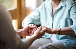 Closeup shot of a young woman holding a senior woman's hands in comfort